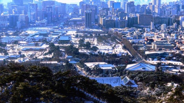 Snow-covered traditional buildings among modern cityscape in winter