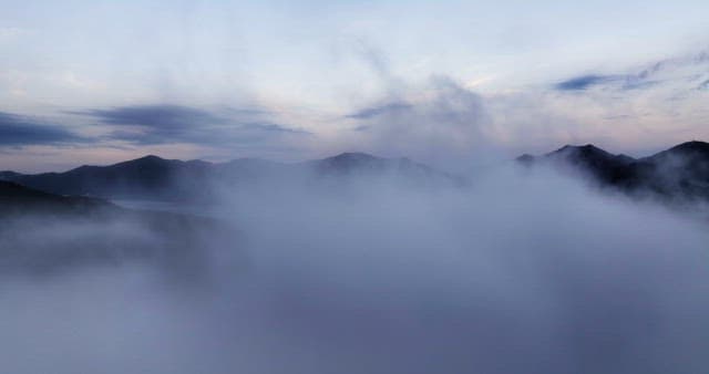 이른 아침 안개에 둘러싸인 산