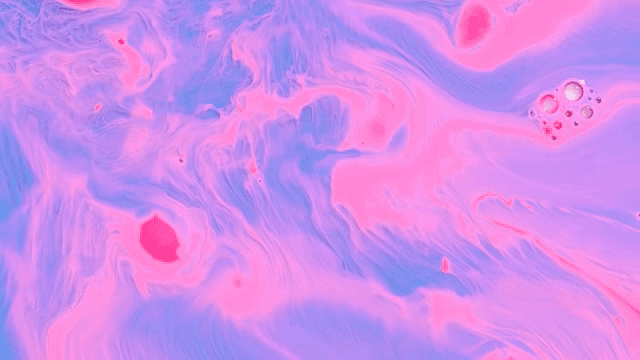 Abstract pattern of blue and pink liquids mixing together