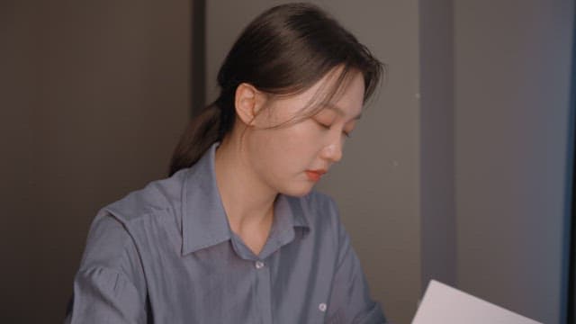 문서를 읽는 데 집중하는 여성