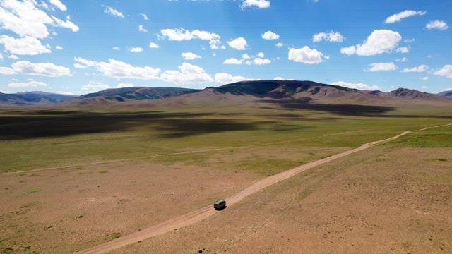 Vehicle on a Quiet Road in a Barren Grassland