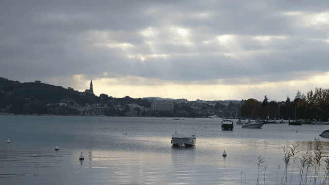 Tranquil lake with boats and distant villages