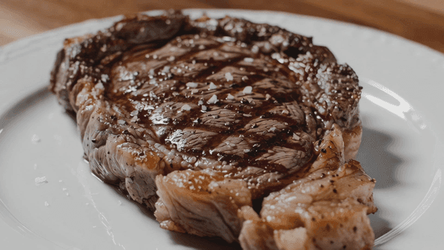 Grilled steak on a white plate