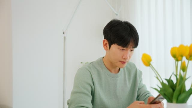 Man using a smartphone in a room with white interior