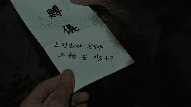 친구의 안부가 적힌 부의금 봉투를 들고 있는 사람