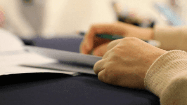 A person writing notes on paper