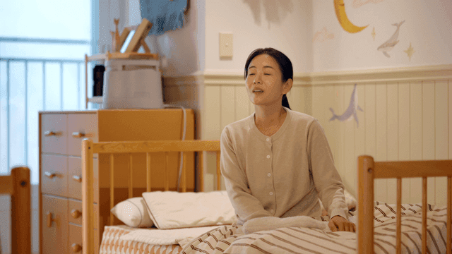 Woman sitting on bed in child's room