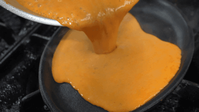 Rose sauce poured from pan onto griddle