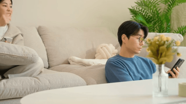 Two people bickering while looking at their smartphones in the living room