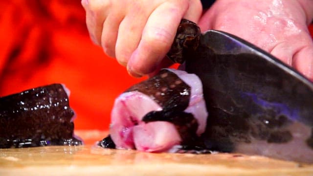 Cutting fresh sea raven with a sharp knife