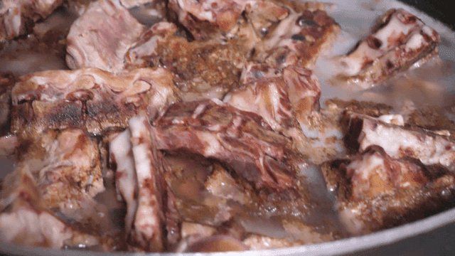 큰 냄비에 삶아진 뼈 붙은 고기