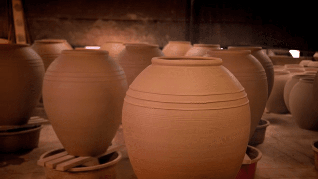 희미한 조명이 켜진 방에 놓인 점토 항아리