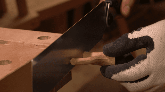 톱으로 고정된 나무를 자르는 손