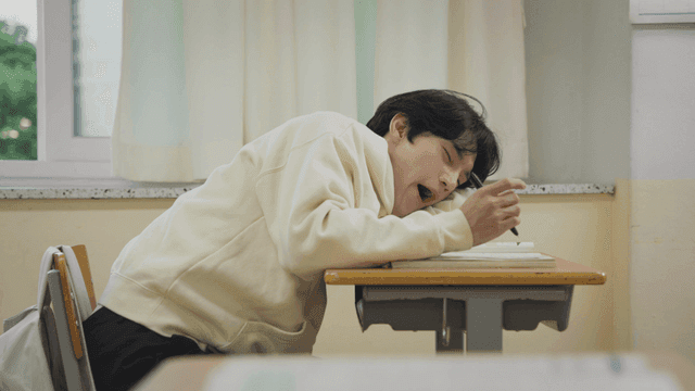 엎드려 공부하다 하품하는 졸린 학생