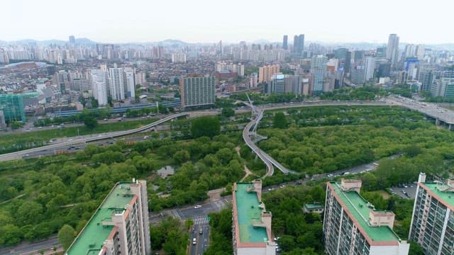 Aerial View of Urban Park by Dense Cityscape