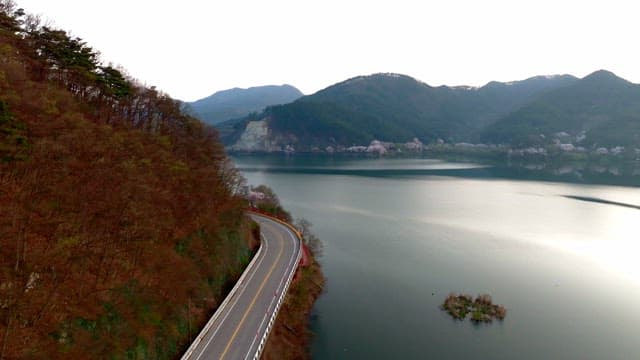 Winding road by a serene lake