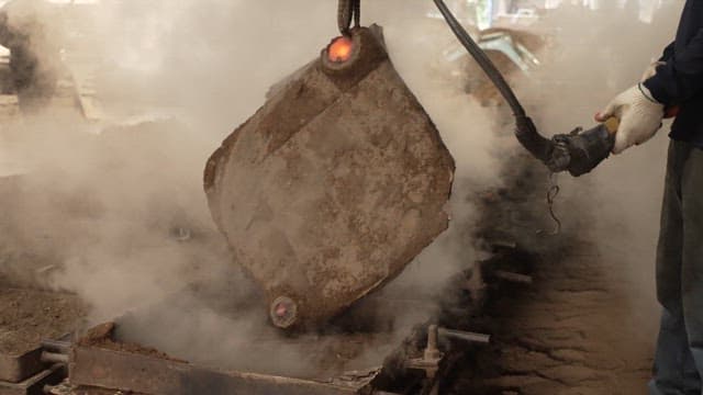 Worker handling a large metal mold