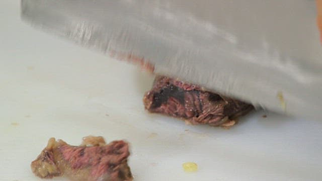 Slicing cooked meat on a cutting board