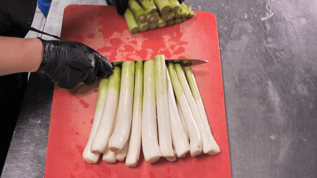 Chopping green onions on a red cutting board