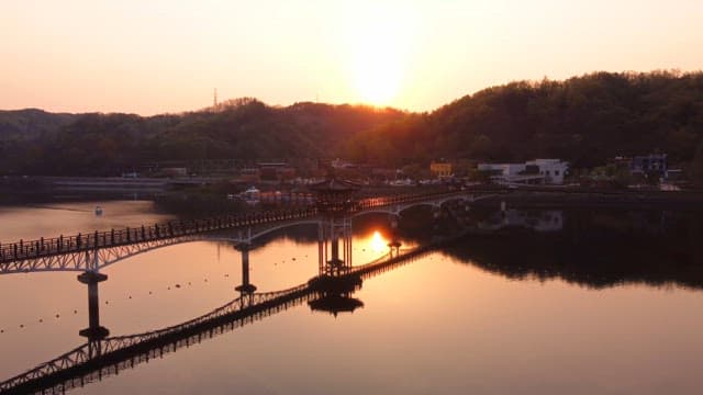 Bridge over a calm lake at sunset