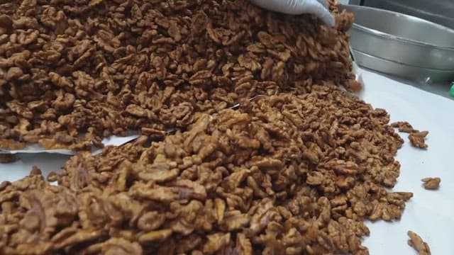 트레이로 옮겨지는 잘 구워진 견과류 호두