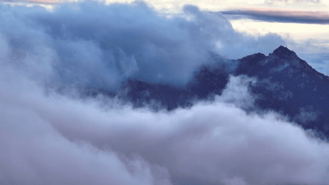 Clouds enveloping a mountain peak