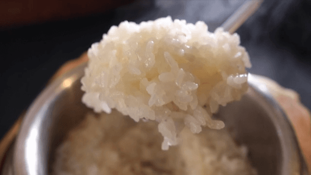 Steaming white rice in a metal pot