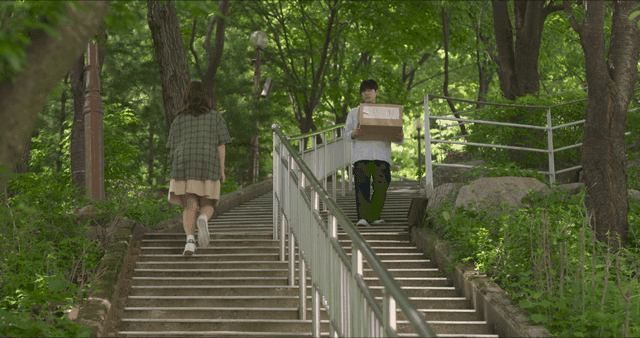 Man with box meeting woman on stairs