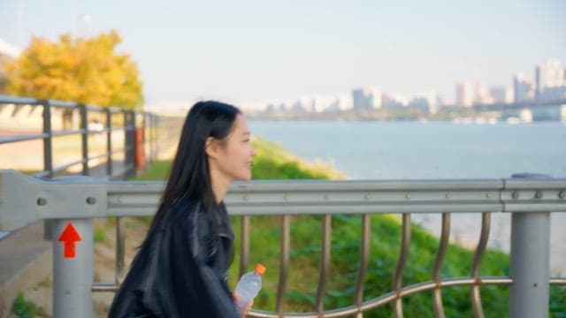 Woman drinking water while jogging