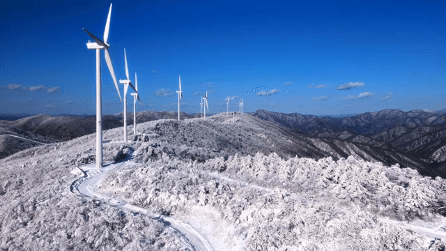 눈 덮인 산과 풍력 터빈