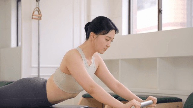 Woman practicing pilates on a reformer