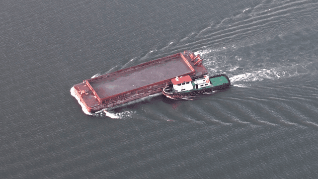 큰 바지를 물 위로 이끄는 예인선