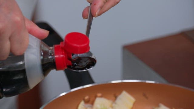 Adding soy sauce to the skillet with the chopped bamboo shoot