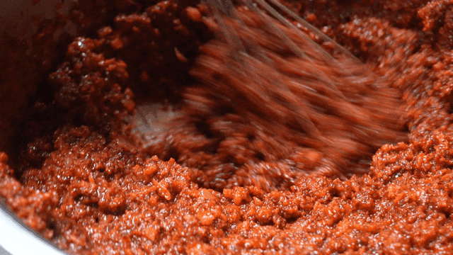 Mixing red chili paste in a bowl