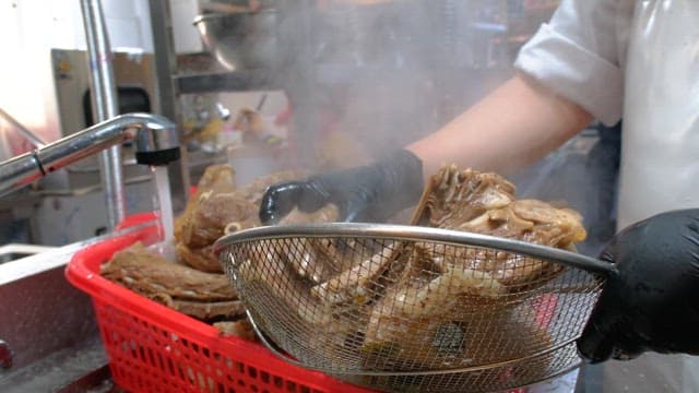 Rinsing boiled pig's feet and meat in water in the kitchen