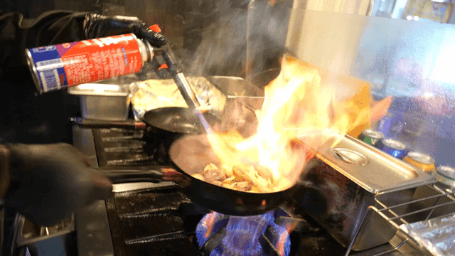 Chef cooking with a torch in a kitchen