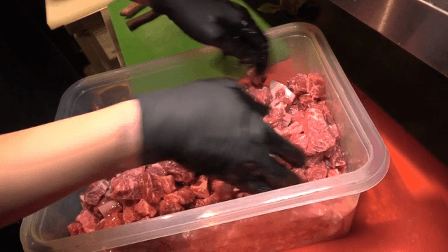 용기에 담긴 생고기를 섞는 손
