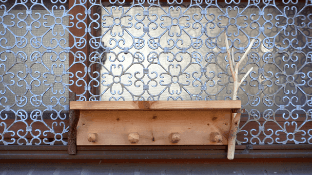 반복되는 문양의 창틀에 달린 나무 선반