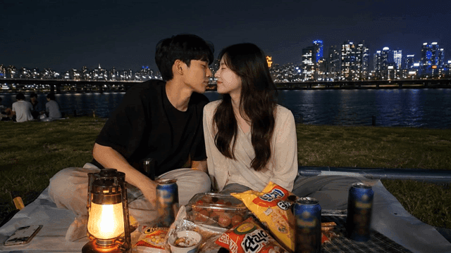 Couple kissing at night picnic by river