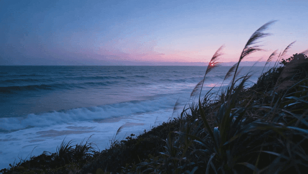 Waves crashing on the shore at sunrise