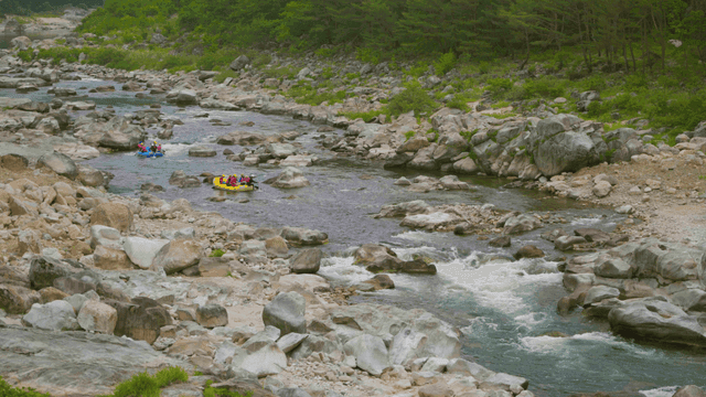 바위가 많은 강에서 래프팅을 즐기는 사람들