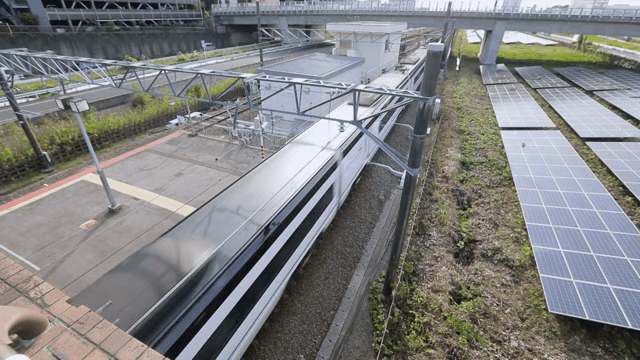 기차역에서 태양광 패널 옆을 지나가는 기차