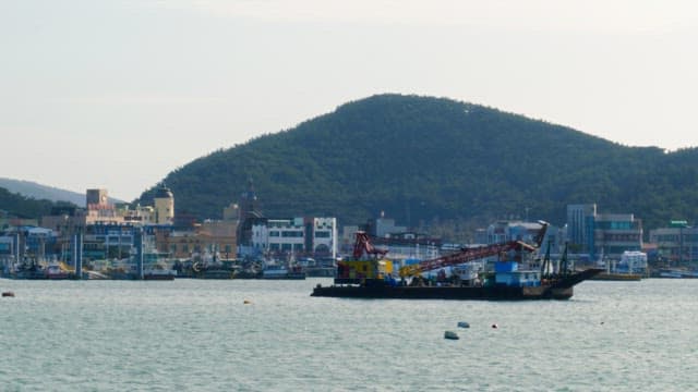 Anchored ships in a port town surrounded by mountains