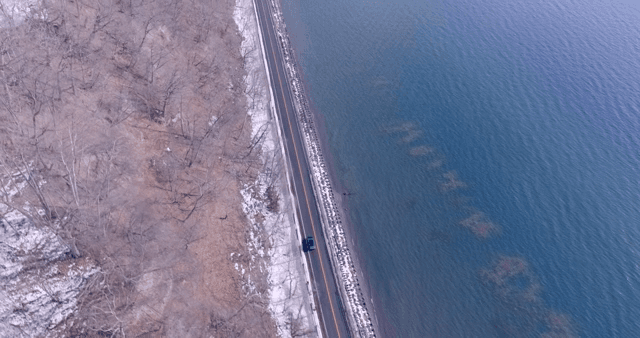 Road along a snowy forest and sea
