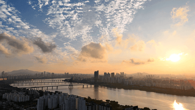 Sunrise over a city skyline with a river