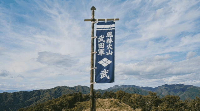 A flag with Japanese characters on a mountain