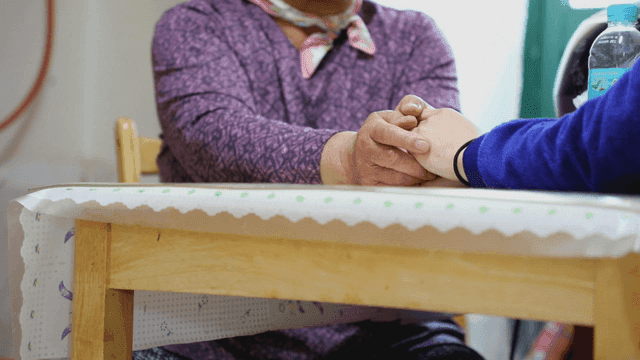 테이블에서 손을 잡고 있는 두 사람