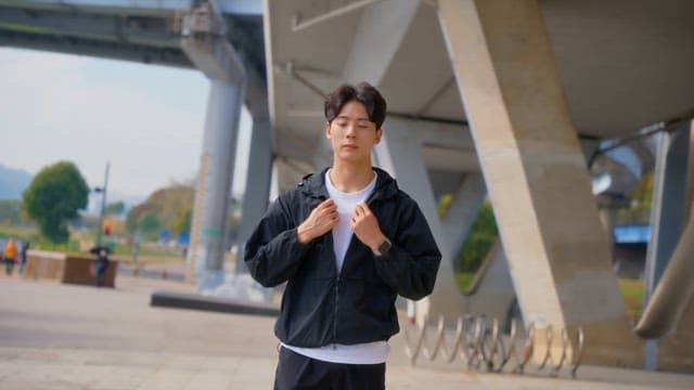 Young man standing under a bridge