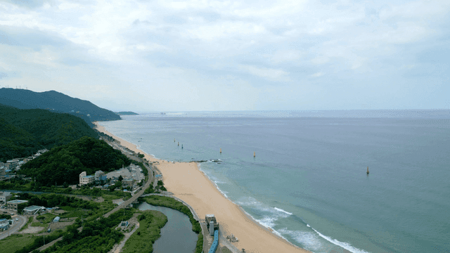 Tranquil beach with waves and mountains