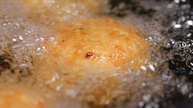 Golden brown potato croquette frying in hot oil